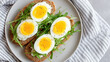 © AnyPic289 - Soft boiled egg slices on whole grain bread with fresh arugula and black pepper served on white plate for healthy meal