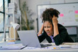 © Parichat - Stressed manager working on a laptop and having a bad headache in the office