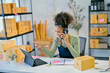 © Parichat - Smiling african american woman managing online store using tablet and smartphone