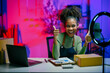 © Parichat - Young african american woman showing thumbs up recording video for social media selling products online