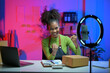 © Parichat - Happy african american business woman live streaming, selling online, working from home