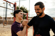 © kleberpicui - Teenage boy and adult man smiling and shaking hands after outdoor workout