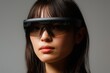© Wirestock - Young Asian woman wearing futuristic augmented reality glasses.