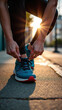 © DBA - A runner ties their shoelaces on a sunlit pavement, preparing for a morning jog or evening run.