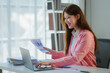 © PaeGAG - Asian businesswoman working with financial data in office
