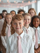 © Surachetsh - a proud young leader student in a white shirt and pink tie, leading a group of elementary school peers with a smile that reflects their natural leadership.