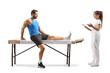 © Ljupco Smokovski - Athlete with a leg injury talking to a female therpaist
