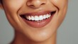 © Johannes - close up face of young woman with beautiful smile isolated on grey wall with copy space successful multiethnic girl latin woman looking at camera against gray wall with a big whitening teeth smile no