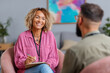 © Anastasiya Marchenko - Close-up of smiling Black female therapist during warm and professional consultation