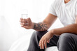 © Prostock-studio - Cropped millennial caucasian muscular man hold glass of clean water on light background, indoor, profile, copy space. Health care, water balance, diet and proper nutrition for male beauty, close up