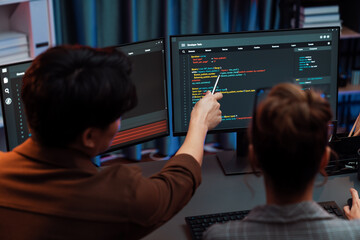Smart IT developer looking at coding program application on computer screen of online website at back side, analyzing intelligent database system development on business marketing at office. Infobahn.