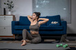 © Apichat - Young asian woman stretching neck muscles during home workout