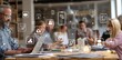 © Dauri - Business team collaborating around a table in a bright space, surrounded by floating icon symbols