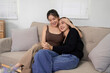 © Pichsakul - Asian Adult Women Lesbian Couple Embrace Holding Hands Sofa Love Cozy Home Living Room Happiness Sweet Moments Relationship Connection