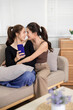 © Pichsakul - Asian adult lesbian couple sharing loving moment on sofa watching phone at home cozy living room intimate connection romantic partnership modern lifestyle