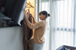 © Charlie's - Asian girl preparing vacation choosing clothes with wardrobe in bedroom before holidays trip