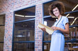 © wavebreak3 - African American woman reviewing file folder in hallway wearing scrubs with stethoscope, copy space