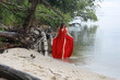 © Сергей Луговский - Young beautiful brunette woman in long red dress standing on the sand near sea