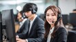 © The Little Hut - Smiling Asian Customer Service Representative with Headset in Busy Call Center Environment
