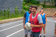 © unai - Rugby player smiling and holding ball during training with teammates