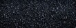 © SARPIA - Close-up view of a textured black gravel surface, showcasing various stone sizes and shapes
