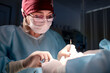 © Georgii - Surgeon performing detailed procedure in a modern sterile operating environment