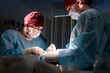 © Georgii - Surgeons performing precise medical operation in a well-lit surgical room