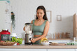 © Pixel-Shot - Sporty young happy Asian woman making protein shake at home