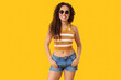 © Pixel-Shot - Beautiful African-American woman with sunglasses on yellow background