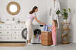 © Pixel-Shot - Little girl helping her mother doing laundry at home