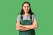 © Pixel-Shot - Young female construction worker on green background. Woman in male profession concept