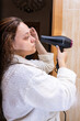 © Ivi - Powerlightss - Woman drying hair with hair dryer after shower in bathroom