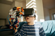 © Westend61 - Boy looking at robotic arm through VR glasses at home
