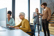 © NDABCREATIVITY - Business woman in wheelchair working with colleague in modern inclusive office. Diversity, support