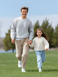© Oksana_Latysheva - Father walking hand in hand with daughter in park. Parenting, family love, bonding moments, outdoor leisure, and generational connection in nature.