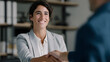 © Oksana_Latysheva - Smiling businesswoman shaking hands during office meeting. Professional handshake symbolizing agreement, cooperation, teamwork, trust, and partnership.