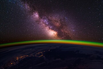 Wall Mural - a cosmic shot capturing the milky way and our planet at dawn from orbit.