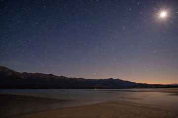 Wall Mural - Star trails over mountain landscape at night