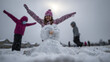 © Nino - joyful winter scene unfolds as children play outside in snowy backyard creating snow angels