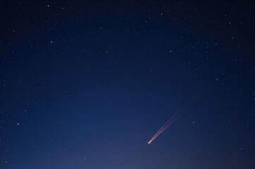 Wall Mural - A solitary meteor streaks across the night sky.