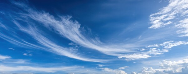 Wall Mural - A vibrant, blue sky fills the frame, streaked with thin, whispy cirrus clouds that fan out across the upper part. Some cumulus at the bottom
