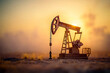 © khozainuzzuhri - Silhouette of an oil pump jack at sunset, capturing the energy industry