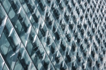 Detailed look at a contemporary structure's exterior featuring diagonal glass and opaque sections in a repetitive arrangement. Abstract design theme. Portrait layout.