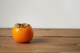 Ripe persimmon placed on rustic wooden background with room for text