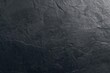 © vxnaghiyev - Dark charcoal slate surface with stone wall texture