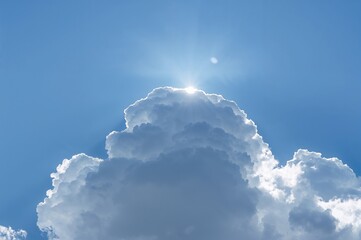 Wall Mural - large fluffy white cloud blocking the sun against a bright blue sky, creating a stunning natural sce