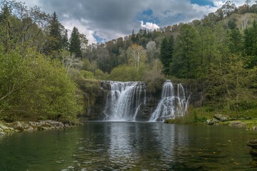 Wall Mural - scenic countryside featuring a cascading waterfall amidst lush greenery