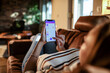 © Geber86 - Young woman using a banking app on her smart phone while lying down on the couch in the living room