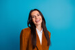 © deagreez - Smiling young woman in formal orange blazer looking confident with a bright hairstyle on a vivid blue background
