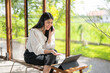 © Apichat - woman is sitting on a chair and talking on her cell phone
